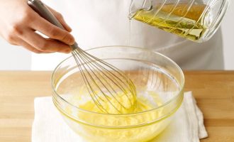 Добавление оливкового масла во взбитые желтки